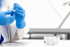 Singota team member applying label to vial Labeling Labeling