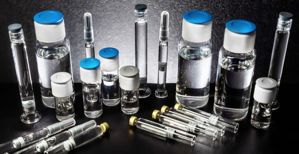 Assorted glass vials and syringes on a dark laboratory counter syringes cartridges and vials syringes cartridges and vials