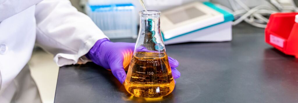 Scientist wearing purple gloves holds an amber liquid in a  mL Erlenmeyer flask at a lab bench ready for experimentation jun updated   pre formulation formulation development jun updated   pre formulation formulation development